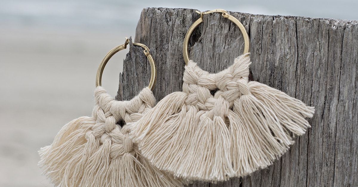 DIY macrame hoop earrings with knotted fringe on gold hoops, finished beginner jewelry project.